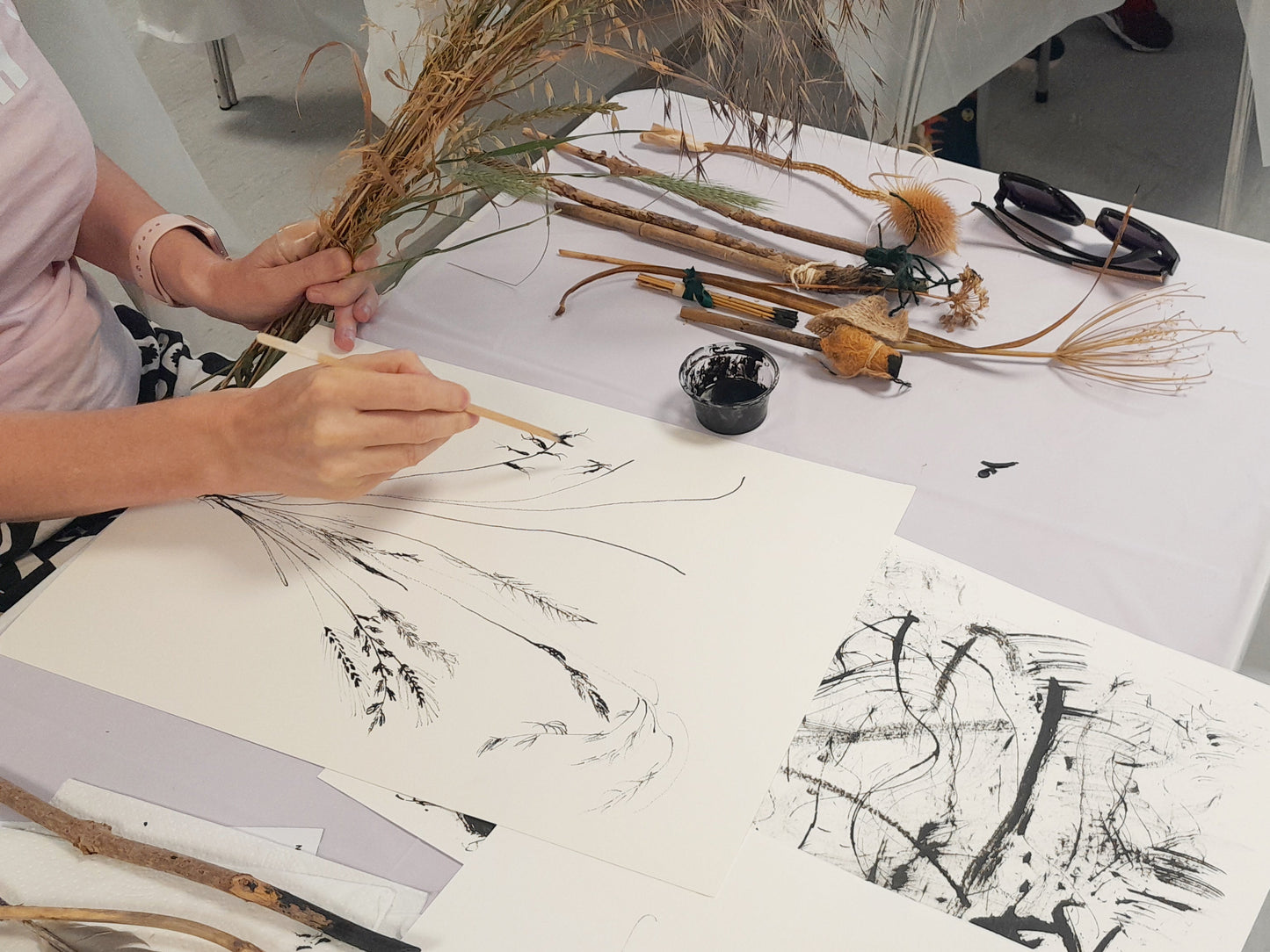 Person practicing calligraphy with brushes and ink on paper