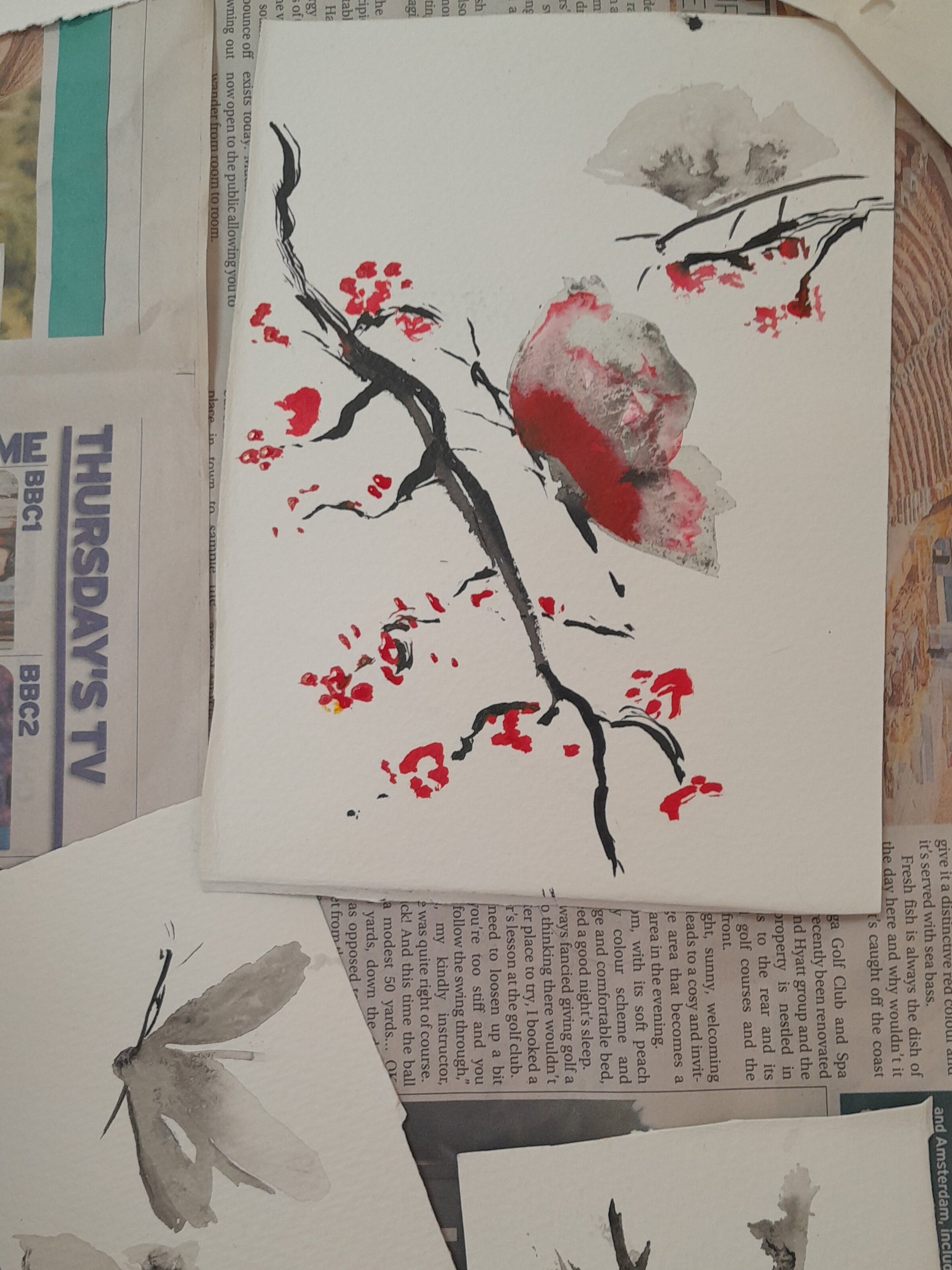 Artistic illustrations of butterflies and branches on newspaper pages.